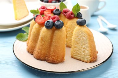 Böğürtlenli kek ve açık mavi ahşap masada nane şekeri, yakın plan.