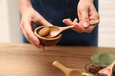 Tahta masada doğal vücut ovucu yapan kadın, yakın plan.