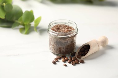 Beyaz masada doğal vücut fırçası ve kahve çekirdeği.