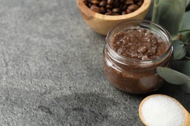 Doğal vücut fırçası cam kavanozda ve gri masada malzemeler, yakın plan. Metin için boşluk