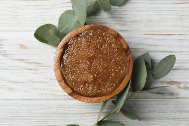 Doğal vücut fırçası kasede ve okaliptüs dalları tahta masada, düz yerde.