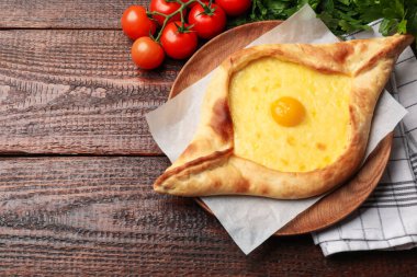 Peynirli, yumurtalı, domatesli, maydanozlu, ahşap masadaki lezzetli khachapuri. Metin için boşluk