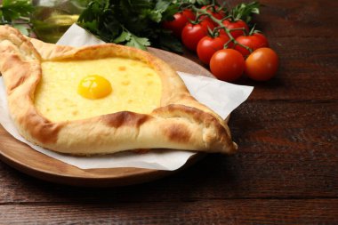 Peynirli, yumurtalı, domatesli ve maydanozlu lezzetli khachapuri, yakın plan. Metin için boşluk