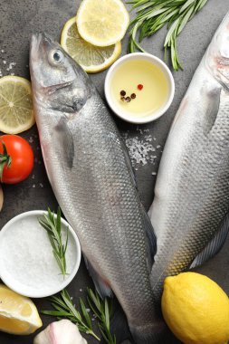 Gri masadaki baharatlı taze çiğ deniz kabuğu, düz. Balık ve deniz ürünleri lezzetleri