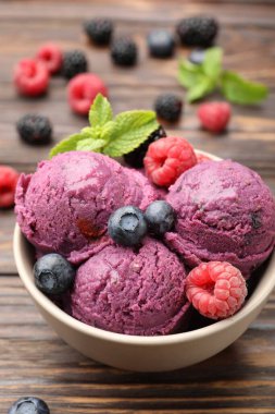 Taze böğürtlenli lezzetli şerbet ve ahşap masada nane şekeri, yakın plan.