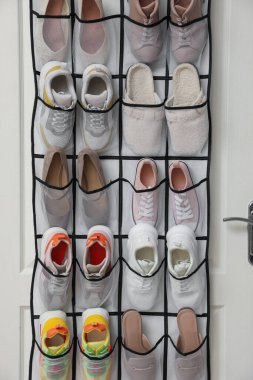 Kapıda farklı ayakkabılar olan bir organizatör. Ayakkabı deposu
