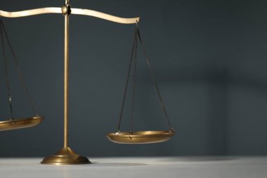 Adaletin terazisi gri arka planda, yakın plan. Metin için boşluk