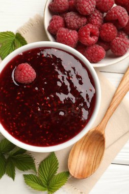 Tatlı ahududu reçeli kasede ve böğürtlen beyaz ahşap masada, düz yatıyordu.