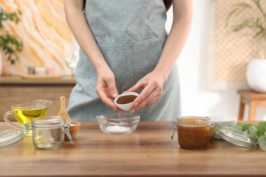 Doğal temizlik yapıyorum. Ahşap masada kahveye kahve katan kadın, yakın plan.