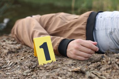 Adli tıp uzmanlığı. Cesedin bulunduğu suç mahalli açık havada, yakın plan.