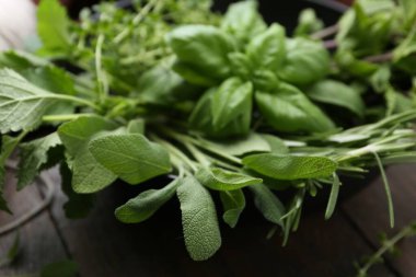 Tahta masadaki kasede farklı yeşil otlar, yakın plan.