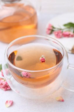 Cam bardakta romatik çay, çaydanlık ve güller ışık masasında, yakın plan.
