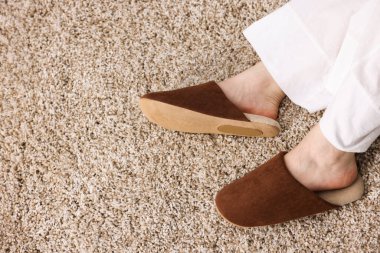 Kahverengi terlikli, bej halılı, üst manzaralı bir kadın. Metin için boşluk