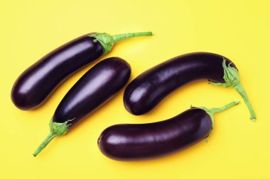 Sarı arka planda olgun patlıcanlar.