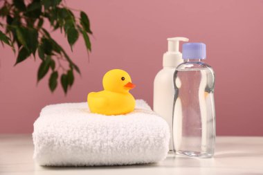 Bebek aksesuarları ve banyo ürünleri beyaz mermer masa üzerinde pembe arka plana karşı