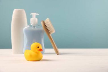 Bebek aksesuarları ve banyo ürünleri beyaz ahşap masa üzerinde açık mavi arkaplan, metin için yer