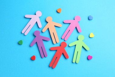 Hoşgörü konsepti. Renkli insan figürleri ve açık mavi arka planda kalpler, düz yatıyordu.