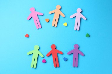 Hoşgörü konsepti. Renkli insan figürleri ve açık mavi arka planda kalpler, düz yatıyordu.