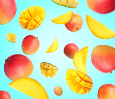 Açık mavi arka planda havada dönen tatlı mango meyveleri