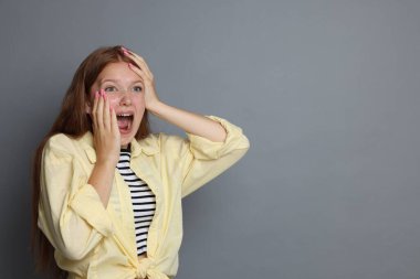 Gri arka planda panik atak geçiren genç bir kız. Metin için boşluk