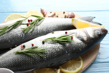 Mavi ahşap masada baharatlı taze çiğ deniz kabuğu, yakın plan. Balık ve deniz ürünleri lezzetleri