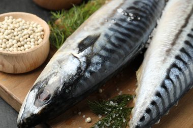 Masada taze çiğ uskumrular ve baharatlar, yakın plan. Deniz ürünleri lezzetleri.