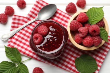 Lezzetli reçel, taze ahududu ve beyaz ahşap masa üzerinde yapraklar, düz uzanmış.