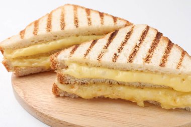 Eritilmiş peynirli lezzetli sandviçler beyaz masada, yakın plan.