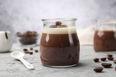 Gri desenli masada nefis panna cotta ve kahve çekirdekleri, yakın plan.