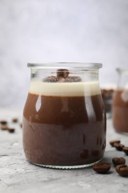 Gri desenli masada nefis panna cotta ve kahve çekirdekleri, yakın plan.