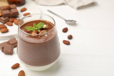 Bademli lezzetli çikolatalı panna cotta ve beyaz ahşap masada nane şekeri, yakın plan. Metin için boşluk