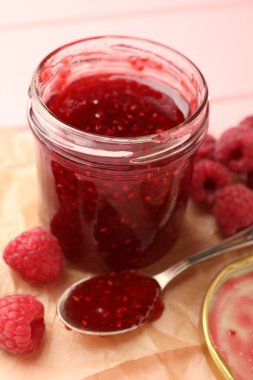 Cam kavanozda tatlı ahududu reçeli ve masada böğürtlen, yakın plan.