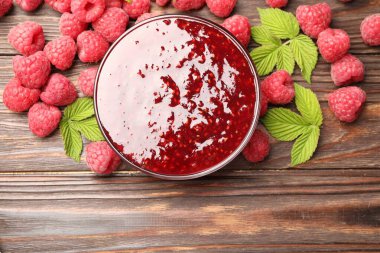 Cam kasede nefis ahududu reçeli, taze böğürtlen ve ahşap masada nane.