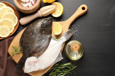 Deniz ürünleri. Taze çiğ balık, baharat ve meyve sıkacağı siyah ahşap masada, düz yerde. Metin için boşluk