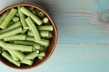 Mavi ahşap masada bir sürü çiğ yeşil fasulye, üst manzara. Metin için boşluk