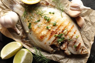Ahşap masada baharatlı, kavrulmuş balık, düzlük. Ev yapımı deniz ürünleri yemeği.