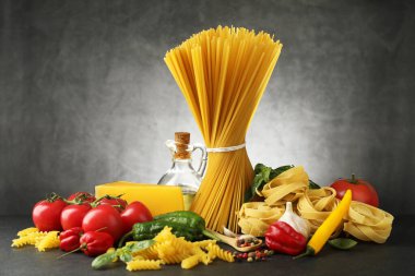 Siyah masada değişik makarna ve malzemeler var.