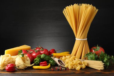 Tahta masadaki farklı makarna ve malzemeler.