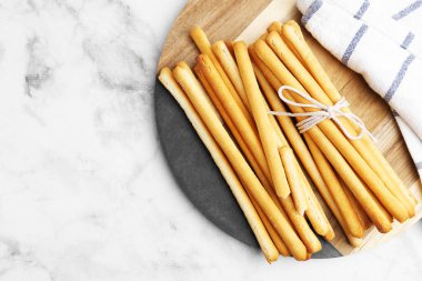 Lezzetli Grissini çubukları ve peçete açık mermer masa, üst manzara. Metin için boşluk