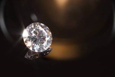 Karanlık ayna yüzeyinde parlak bir elmas, yakın plan. Metin için boşluk