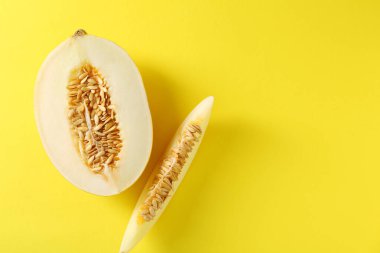 Sarı arka planda taze olgun kavun kes, düz yat. Metin için boşluk