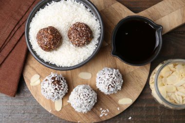 Tahta masanın üzerinde hindistan cevizi taneleri olan nefis ev yapımı şekerler.