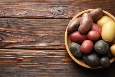 Tahta masadaki kasede farklı patates türleri, üst manzara. Metin için boşluk