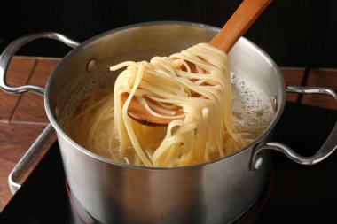 Haşlanmış tagliatelle makarnasını elektrikli ocaktan kaşıkla alıp, yakın plan çekiyoruz.