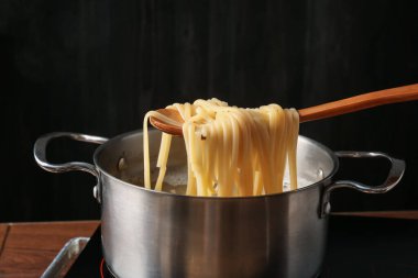 Haşlanmış tagliatelle makarnasını elektrikli ocaktan kaşıkla alıp, yakın plan çekiyoruz.