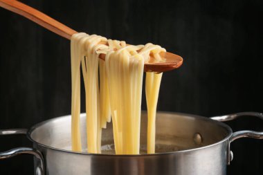 Haşlanmış tagliatelle makarnasını elektrikli ocaktan kaşıkla alıp, yakın plan çekiyoruz.