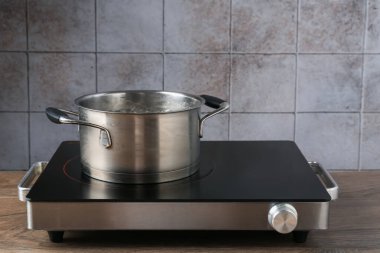 Mutfaktaki ocağın üstünde kaynar su bulunan metal tencere.