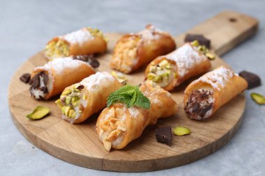 Peynirli, fındıklı, pudra şekerli, çikolatalı ve naneli nefis cannoli, yakın plan.