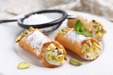 Peynirli, fıstıklı, pudra şekerli ve naneli nefis cannoli, yakın plan.