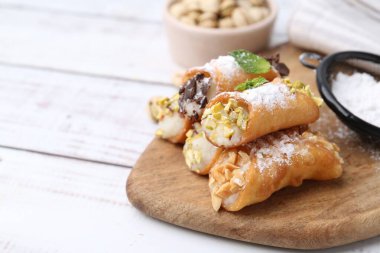 Peynirli, fındıklı, pudra şekerli, çikolatalı ve nane şekerli nefis cannoli, yakın plan. Metin için boşluk